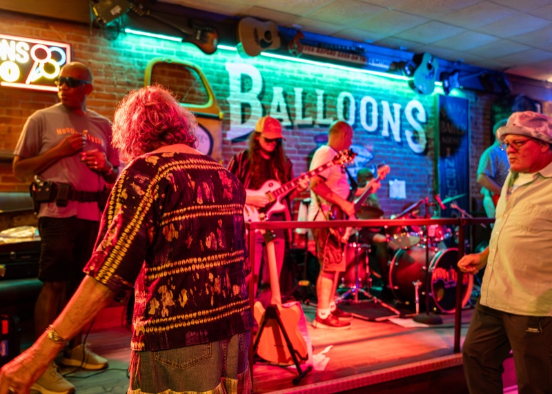 Live band performing on the Balloons stage as guests dance